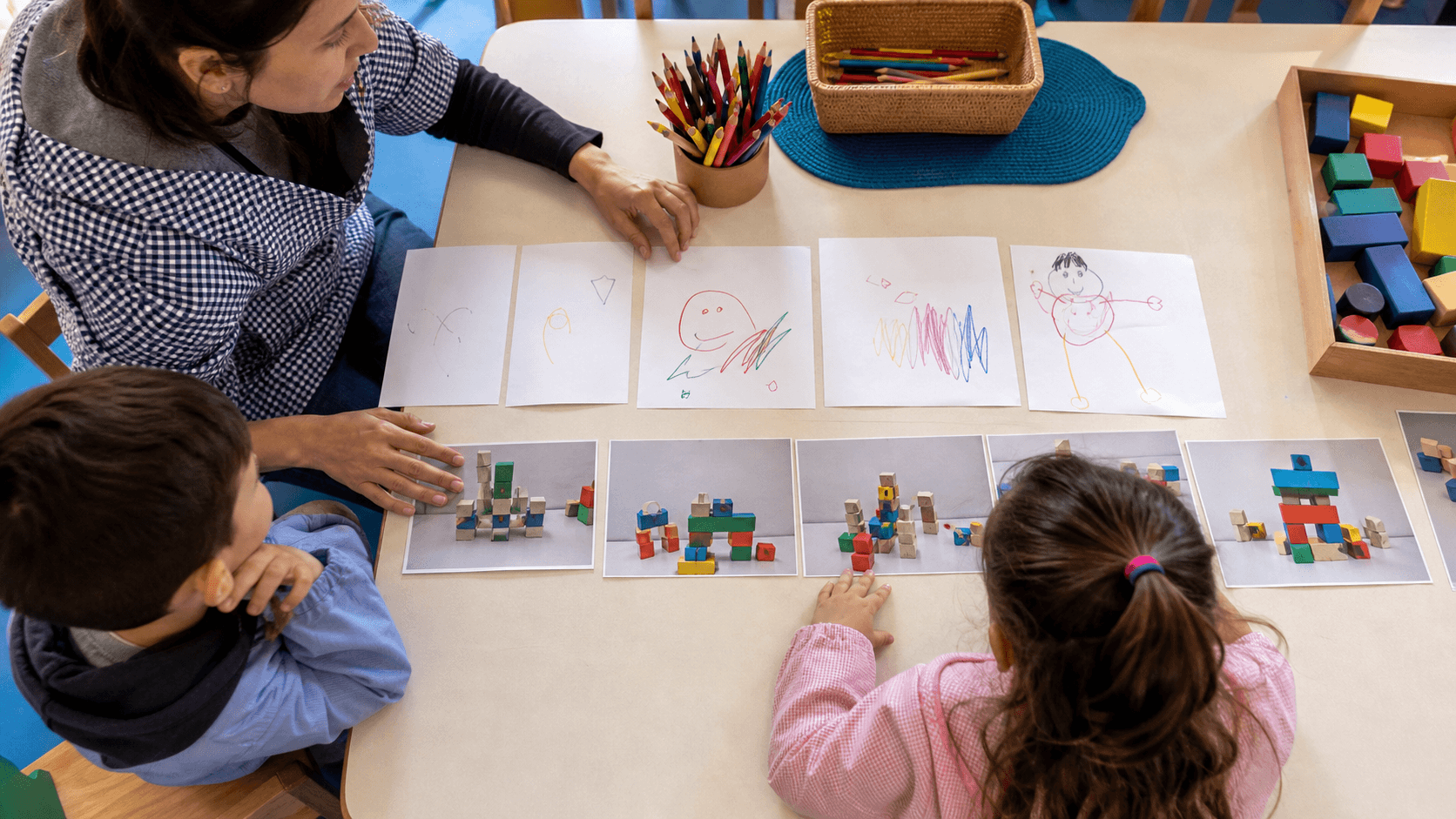 Docente y niños revisando producciones para reconocer avances en Nivel Inicial