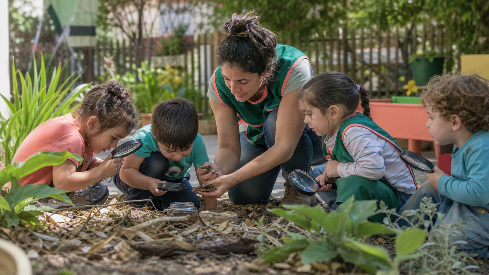 Grupo observando pequeños invertebrados en el patio del jardín